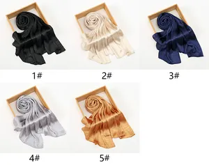 Detailed view of shimmering silk scarves in black, champagne, and navy blue satin textures