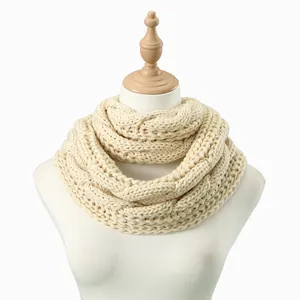 Detailed texture of thick corn cable knit pattern on warm cream infinity scarf