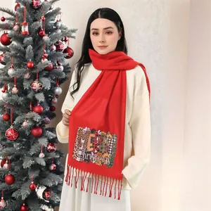 Detail of red Christmas scarf featuring Merry Christmas text with leopard and plaid patterns