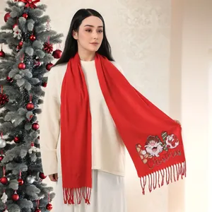 Detail of red Christmas scarf featuring Santa Claus embroidery and soft tassel edge