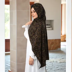 Detail of soft leopard print headscarf in dark brown chiffon fabric on a model