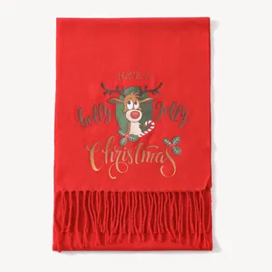 Detail of red Christmas scarf featuring reindeer, holly prints, and soft fringe tassels