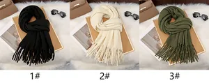 Detail view of milk velvet scarves in black, cream, and olive green with long tassels