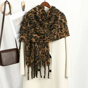 Close-up of leopard print cashmere feel scarf featuring soft tassels and thick warm fabric