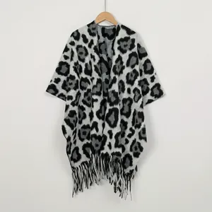 Detailed view of leopard print knit texture and tassel hem on thick winter shawl