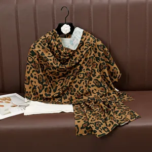 Detail showing high-quality leopard print scarf fabric with a smooth silky texture