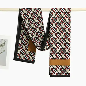 Detailed view of lightweight scarf with geometric print hung on a white bar