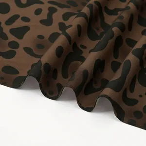 Detailed macro shot of soft leopard print cotton fabric with fine stitching and drape