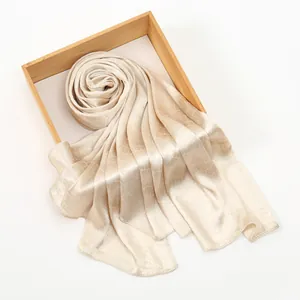 Close-up of champagne scarf showing crocodile texture on a wooden tray