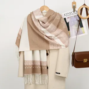 Close-up of beige and brown geometric knit scarf with tassels on wool coat detail
