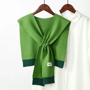 Detail of green knitted shawl with twist design and geometric squid pattern labels