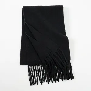 Close-up detail of soft black milk velvet scarf showing warm knitted texture and fringe