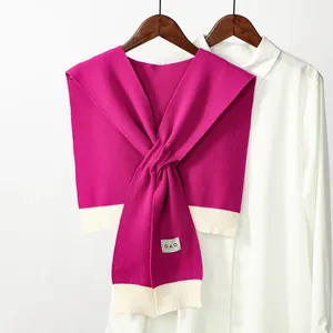 Detail of rose red houndstooth knit shawl with geometric symbols and ribbed trim