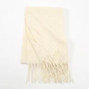 Detail of cream white milk velvet scarf showing soft knit texture and fringe tassels