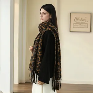 Thick leopard print cashmere-feel winter scarf with fringes worn as a warm shawl