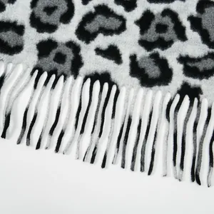 Close-up of leopard print scarf featuring grey tassels and thick premium fabric texture