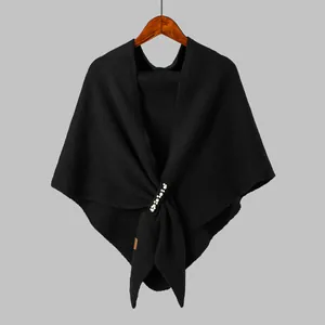 Detail of black knitted shawl featuring white pearl bead embellishments and texture