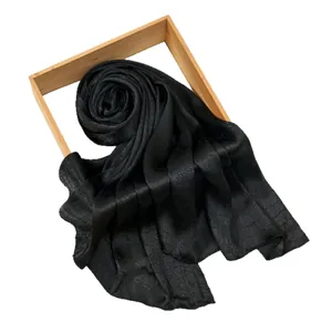 Elegant black silk scarf with snake skin texture displayed on a modern wooden frame
