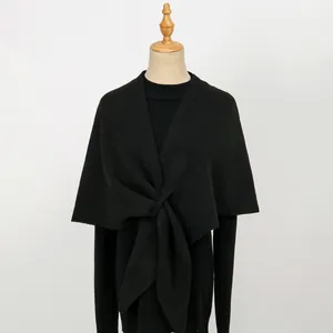 Detailansicht eines schwarzen Strickschals mit modischem Knotendesign auf einer Schneiderpuppe