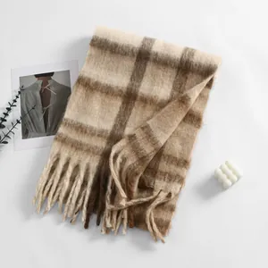 Dettaglio della sciarpa a quadri beige e marrone con texture tipo cashmere e lunghe nappe