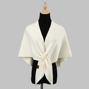 Elegant off-white knit shawl with pearls and twisted design on a black mannequin