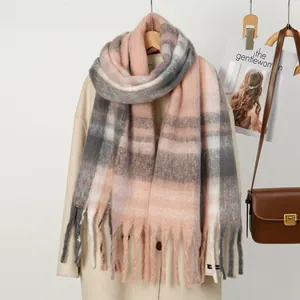 Dettaglio della sciarpa scozzese rosa e grigia con lunghe frange e morbida trama cashmere