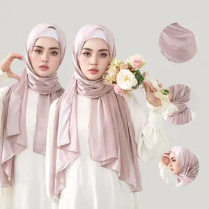 Detail of light pink pleated hijab scarf showing vertical texture and silk-like fabric sheen
