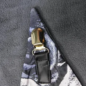 Detail of trendy skull print scarf featuring a golden metal clip and black leather strap