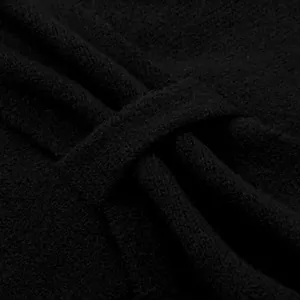 Detailaufnahme des schwarzen Strickschals mit feiner Wolltextur und Knotendesign-Details