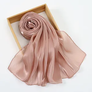 Elegant rose gold silk shawl with pearlescent sheen and fine draping in a wooden frame