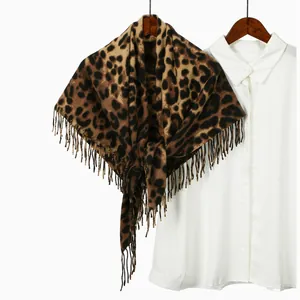 Detail of leopard print cashmere feel scarf with fringe tassels on wooden hanger