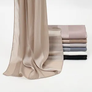 Detail of lightweight pleated floral scarf featuring metallic yarn and elegant texture