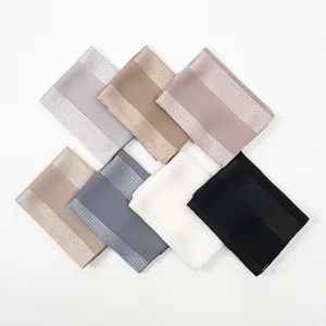 Close-up of silk-textured scarves showing satin finish and fine stripe edge details