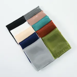 Detail of assorted solid color silk scarves with smooth satin finish and subtle shimmer
