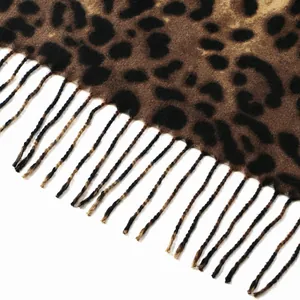 Macro detail of leopard print scarf featuring soft cashmere-like texture and fringed edges