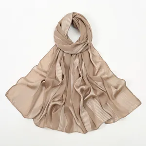 Detail of pleated texture and vertical stripes on a light brown cotton-linen feel shawl