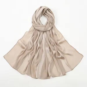 Detail showing pleated champagne linen-touch scarf with a subtle satin texture and fine hem