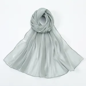 Detail of silver long scarf showing smooth metallic shimmer and delicate hemmed edges