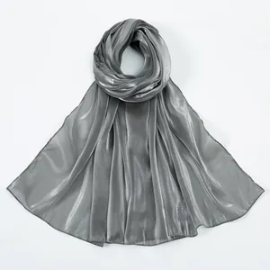 Close-up of shimmering silver-grey silk scarf showing premium fabric texture and metallic shine