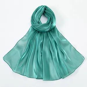 Close-up of lightweight turquoise silk shawl with metallic luster and satin texture