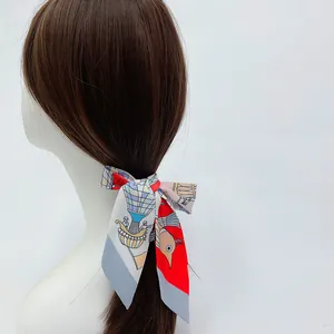 Detail of red and blue printed twilly scarf tied as a hair ribbon on a ponytail