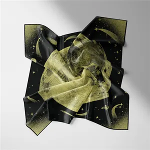 Detail of silk square scarf showing celestial moon and star pattern in black and gold