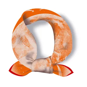 Detail of orange silk square scarf with celestial star patterns and red rolled edges