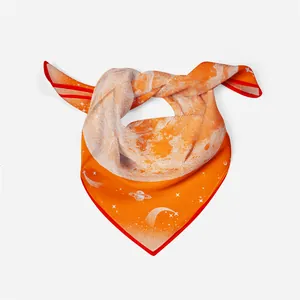 Detail of orange silk scarf with red border and white space-themed cosmic patterns