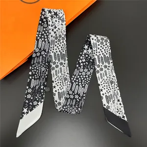 Détail macro du foulard en soie avec motifs géométriques d'étoiles et de fleurs sur noir