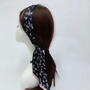 Détail d'un foulard en soie à motif d'étoiles noué sur un mannequin montrant le drapé