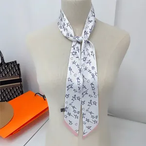 Détail d'un foulard en soie à motif d'étoiles mauves noué sur un mannequin de vitrine