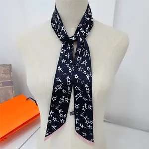 Détail d'un foulard étroit en soie à motif d'étoiles et bord rose comme accessoire de mode