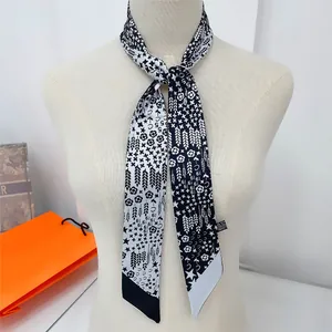 Détail d'un élégant foulard en soie noir et blanc avec motifs floraux sur le cou
