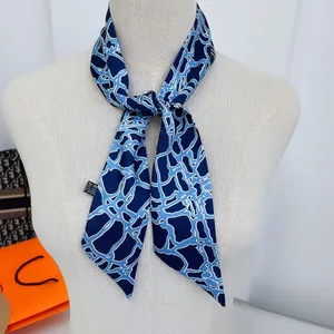 Blauw-witte zijden sjaal met abstracte geometrische print op een witte paspop